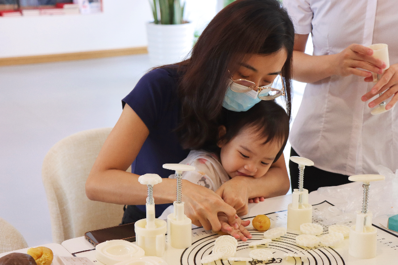 市民带着孩子尝试做月饼.jpg
